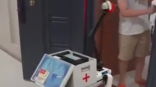 A robot gives an injection to a man in a hospital in China