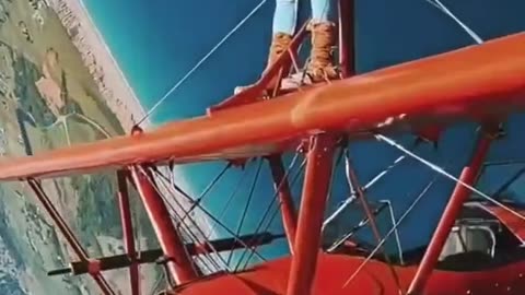 MAN STANDS ON A PLANE WHILE IN-AIR
