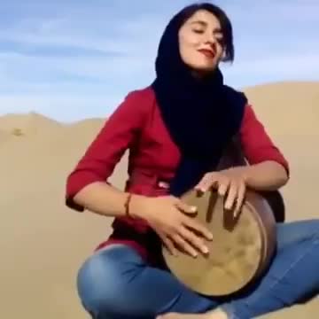 Girl playing Tombak in desert