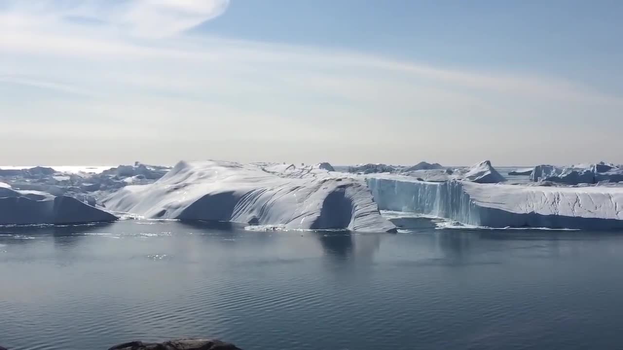 Ilulissat Icefjord - Large iceberg breaking over