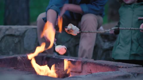 Family roasting marshmallows over a campfire