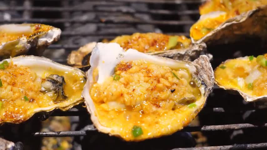 Oysters sizzle on a high fire grill