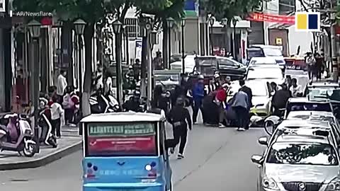 Chinese passers-by lift car up to free trapped boy