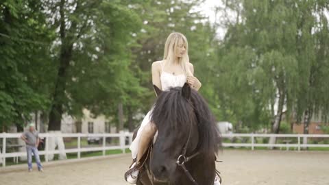 Milennial woman riding a horse at horse club