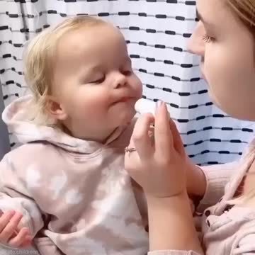 A mother baths her little daughter