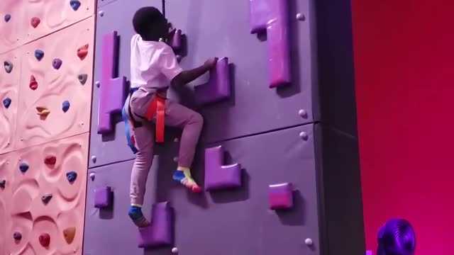 Kid Climbs Indoor Rock Wall And Rings Bell On Reaching Top