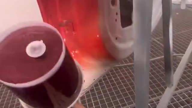 Spray a layer of red car paint on automotive sheet metal