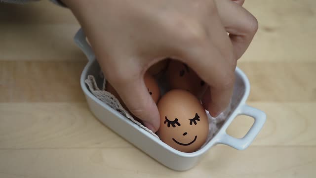 Chicken Eggs With Painted Faces Placed In Container
