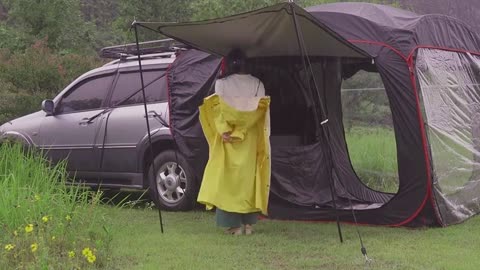 A man cooks outdoors in the rain