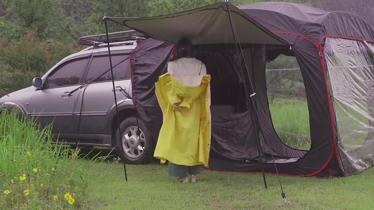 A man cooks outdoors in the rain