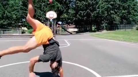 Guy Throws Football Into Basketball Hoop in a Handstand Position
