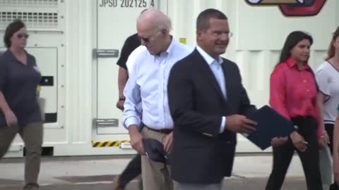 Biden appears to search for something on the floor.