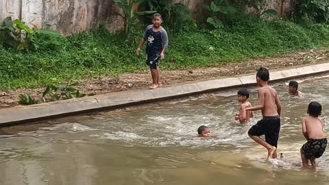 Mandi di sungai yang kumuh
