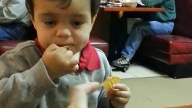 Little boy attempts to drink hot sauce through a straw.