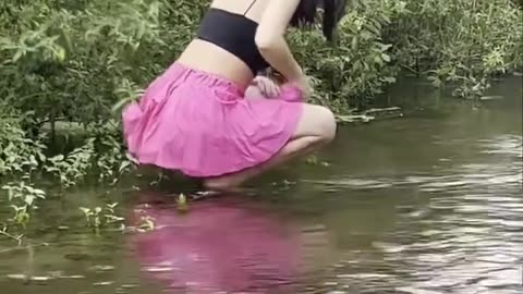 Viral and cute girl in pink skirt having fun in river