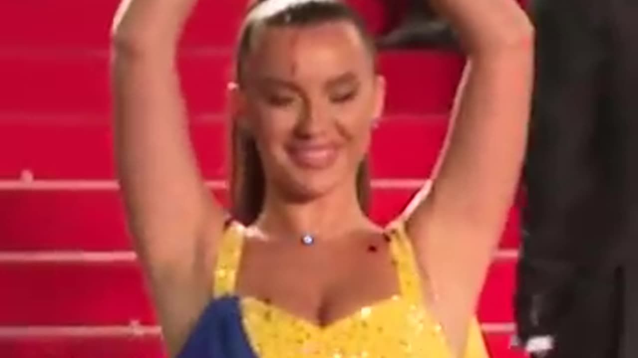 Protester pours fake blood on herself with ukranian flag dress.