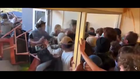 Dozens of pro-Palestine protesters blocking the entrance of a building at California University