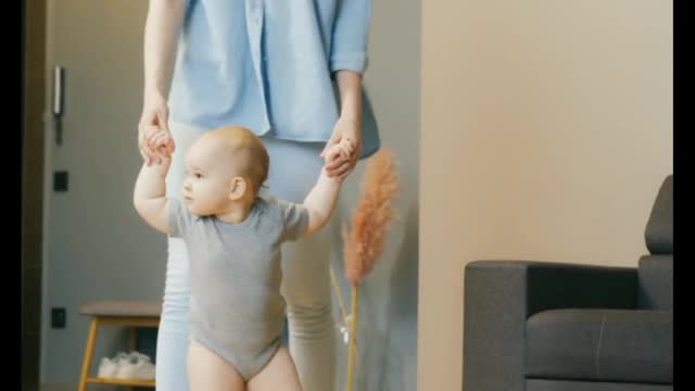 Mother teaching to her baby walk