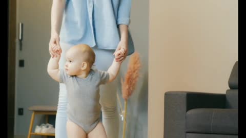Mother teaching to her baby walk