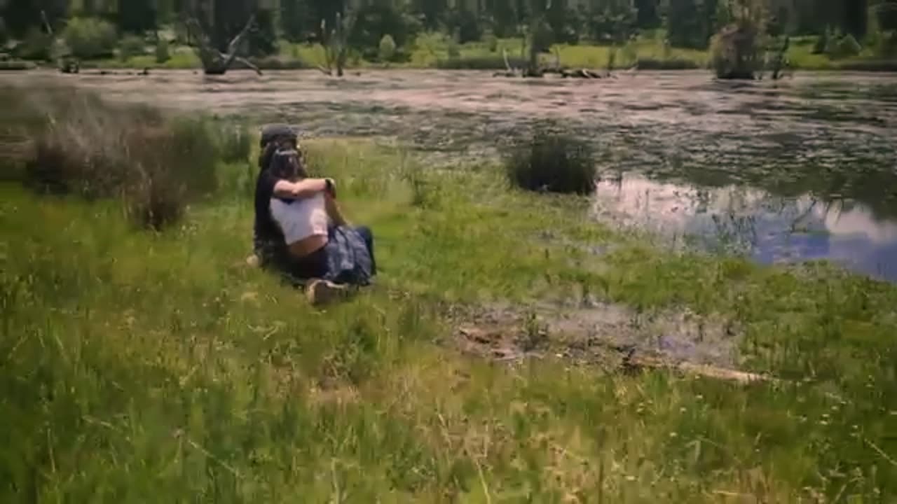 Loving couple sitting on the shore of a lake outdoors