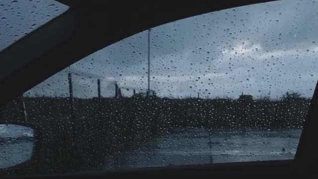 torm and then big rain drops on a car windshield.
