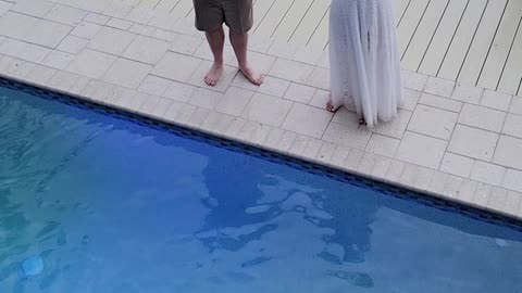 Bride and groom jump in pool