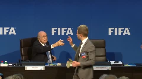 Moment Sepp Blatter was showered with fake dollar bills - BBC News