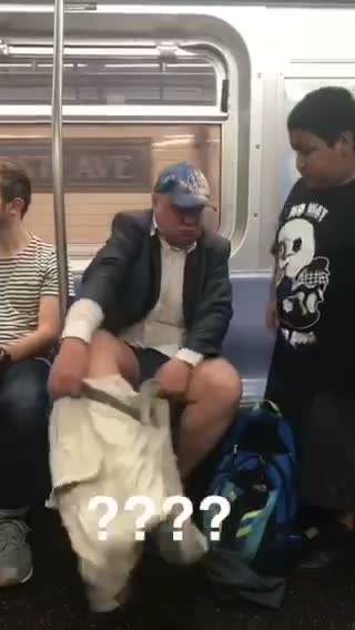 Guy putting on khaki pants on subway blue hat