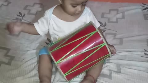 Cute little baby boy playing with dhol