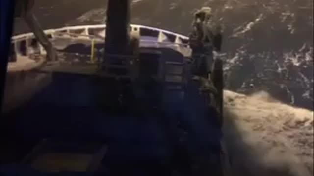 Fishing Boat Passes Through Rough Waves While Snowstorm Hits Sea At Night