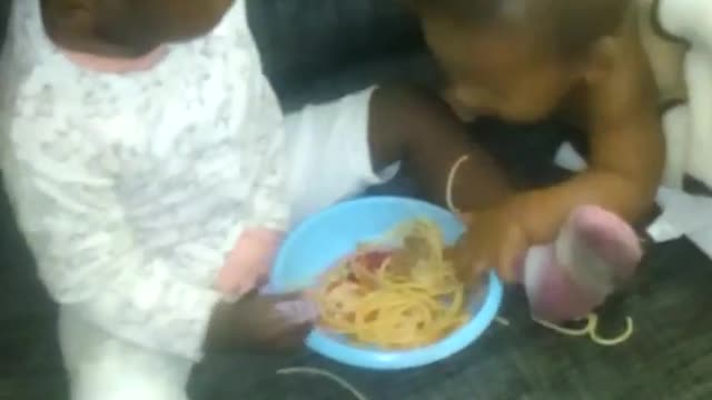 El bebé agarrando la comida de su prima