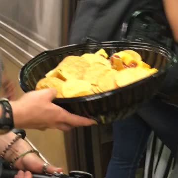 Woman boards train with bike and chips in one hand