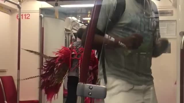 Guy rapping lady in grey with red feather wings dancing moving towards him