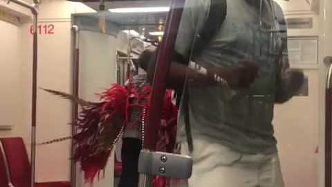 Guy rapping lady in grey with red feather wings dancing moving towards him