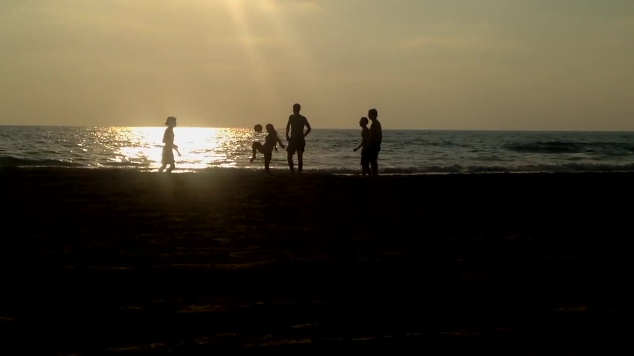 Playing Kickball At The Beach During Sunset