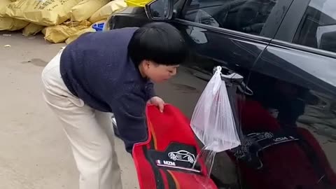 Funny woman Washing car with a plastic of water