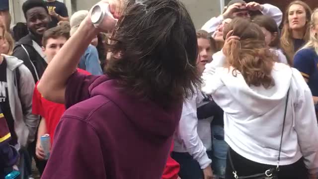 Teen in purple sweatshirt cracks beer over head and chugs it