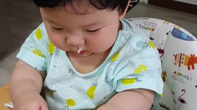 This is a video of a baby eating delicious rice grass.