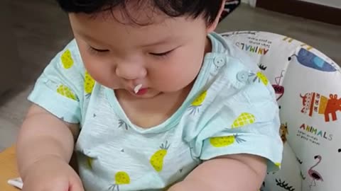 This is a video of a baby eating delicious rice grass.