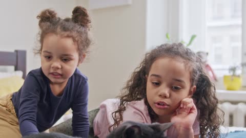 kids petting their cat on the bed in my home