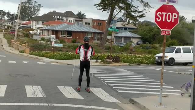 Guy skiing on streets with rollerblades red white black jacket