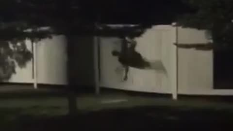 Black clothing throws self through white fence
