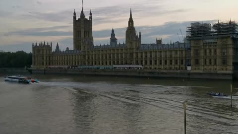 boat on the thames past the house of parliament