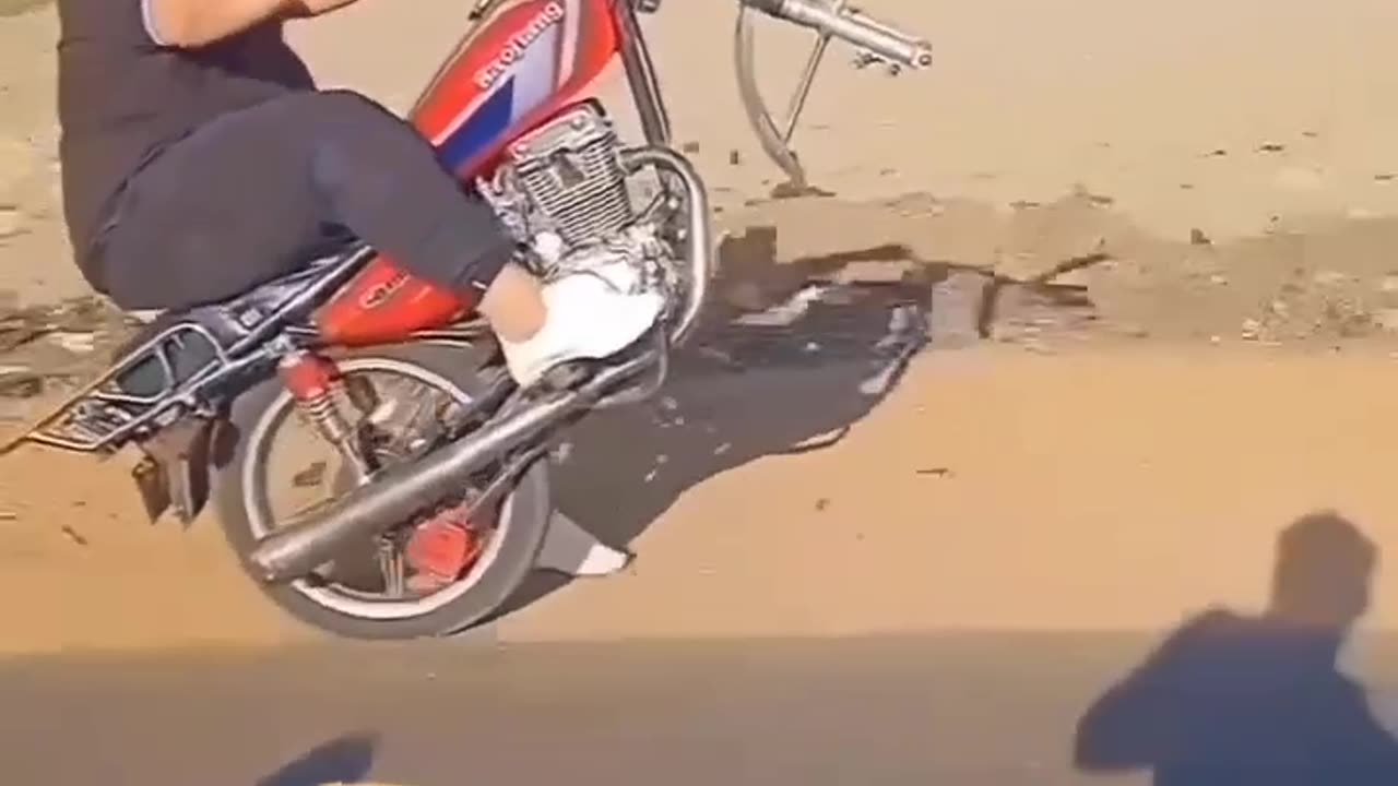 Riding a motorcycle without a front wheel on the rack and falling