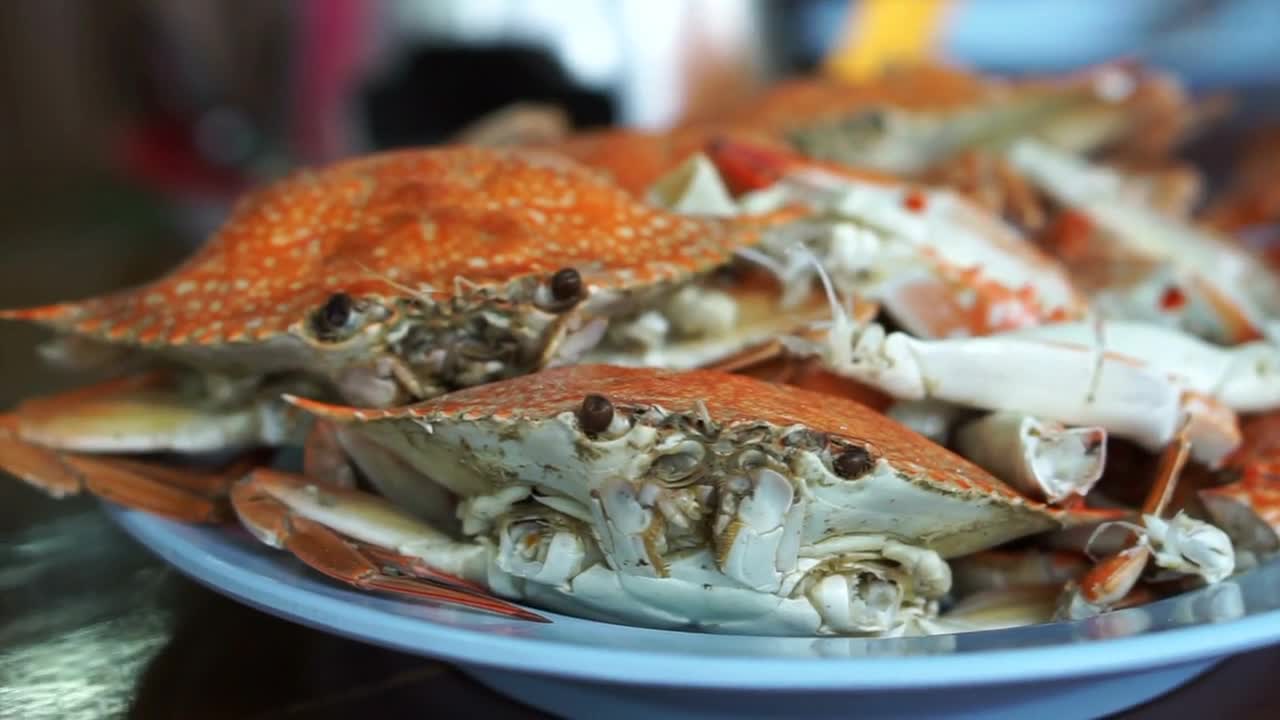 Thai seafood dish. Orange cooked steamed blue crabs on big plate