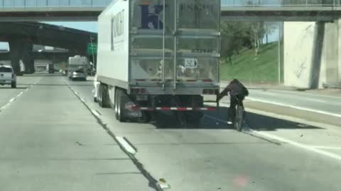 Cyclist Hitches Ride on Semi Truck on Highway