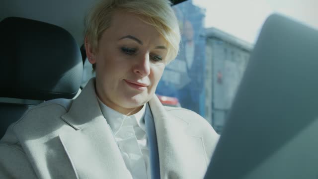 A Woman Working Inside a Traveling Car