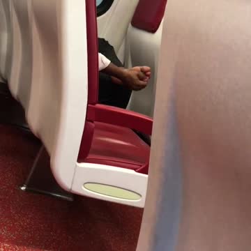 Train red seats person guy rubbing massaging feet
