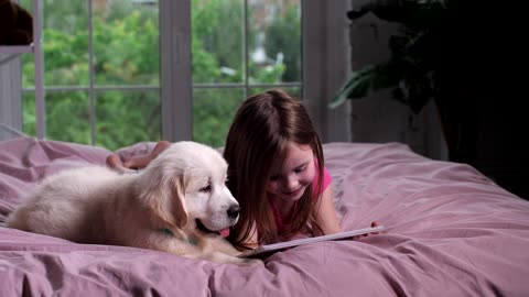 Girl and her puppy watching videos