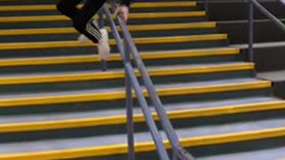 Boy slides down staircase hand rail and falls backwards